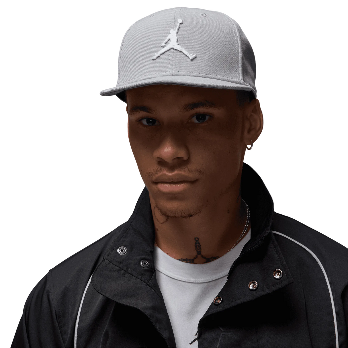Person wearing a gray cap with a logo on a gray background