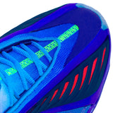 Close-up of a blue athletic shoe showing the side panel with neon green knit accents and red detailing, photographed on a light gray background.